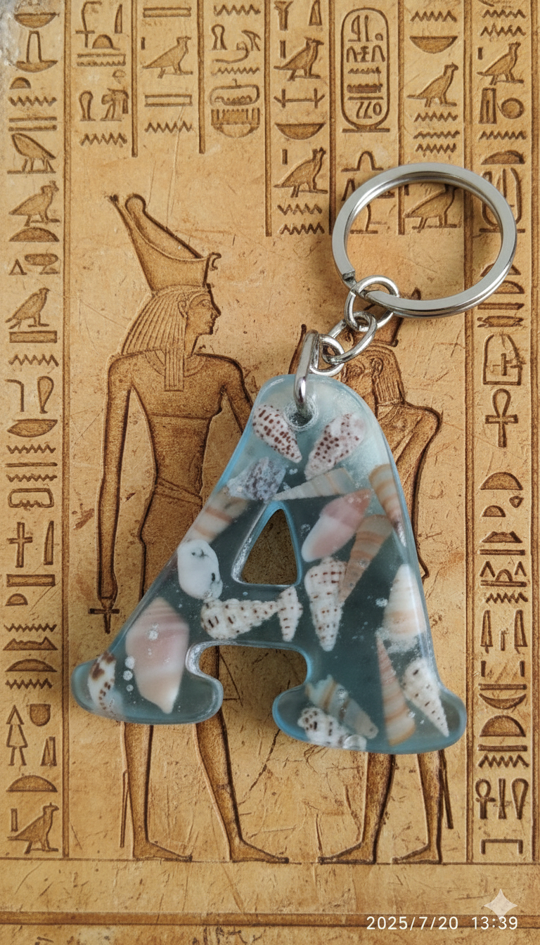 denizin dinginliğini cebinizde taşıyın. bu seri, açık mavi pigmentle renklendirilmiş uv dirençli epoksi içinde gerçek minyatür deniz kabukları ve ince sahil kumu kullanılarak tek tek elde üretilir. her harf dökümden önce kompozisyon olarak hazırlanır; kabarcık kontrolü yapılarak dökülür, kürünü tamamladıktan sonra ıslak zımpara → parlatma aşamalarından geçer. sonuç; cam berraklığında, pürüzsüz ve sağlam bir sahil temalı anahtarlık. benzersizlik bildirimi • fotoğraflar örnek kompozisyonlardır; kabuk türü, dizilimi ve kum dokusu doğası gereği her parçada kısmen farklıdır. • gönderilecek ürün, renk tonu ve tema olarak aynı olmakla birlikte tektir; seri üretim değildir. • her parça paketleme öncesi optik berraklık, yüzey kalitesi ve halka/klips sağlamlığı açısından kalite kontrolden geçirilir. malzeme & işçilik • reçine: sararmaya karşı güçlendirilmiş iki bileşenli epoksi, açık mavi (lagün) pigment. • İçerik: gerçek deniz kabukları (çeşitli minyatür türler) + ince taneli kum. • metal aksam: nikel renkli halka ve zincir. • boyut (yaklaşık): harfe göre 4–5 cm yükseklik; halka ile toplam uzunluk 9–11 cm. • ağırlık: 12–20 g (harf ve kompozisyona göre değişir). kullanım & bakım • kimyasal deterjan ve alkol bazlı temizleyiciden uzak tutun; gerektiğinde yumuşak, kuru bezle silin. • epoksi cam benzeri serttir; aşırı darbe ve yüksek ısıdan kaçınınız. • havuz/deniz sonrası metal aksamın ömrü için kurulayınız. paketleme • her ürün, çizilmeyi önleyen iç kılıf + darbe emici ped ile hediyelik kutu içinde gönderilir. satış notu • mevcut stoktaki harfler satışta aktiftir; listede görünmeyen harfler stokta yoktur. • Özel istek/kişiselleştirme bu seri için yapılmamaktadır.